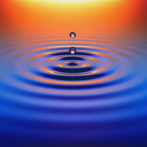 Water drops create ripples at sunset
